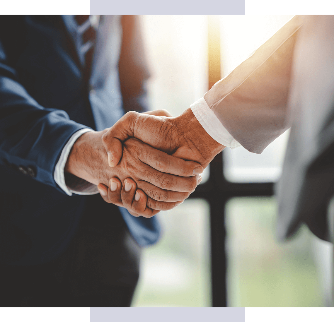 Handshake over desk with laptops